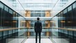 © DSimage - Arafed man in a formal suit stands confidently within a modern glass building, showcasing professionalism and elegance in a contemporary setting.