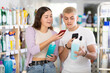 © JackF - Positive young guy and girl scanning barcode on shampoo or shower-gel in department store