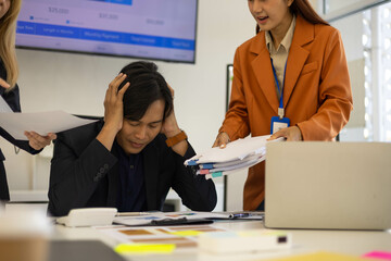 Three people are in a meeting room, with one of them pointing at a laptop screen. The man on the laptop is looking down, and the other two people are looking at him. Scene is tense and serious
