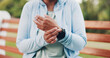 © peopleimages.com - Person, hands and wrist injury with pain on park bench for muscle tension, strain or artery in nature. Closeup, runner or ache with watch, sore arm or fingers for vital emergency, fitness or sprain