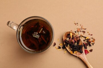 Wall Mural - Aromatic tea and dried leaves on brown background, flat lay