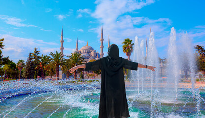 Wall Mural - Young girl in traditional abaya clothes enjoying the view Blue Mosque - The Blue Mosque (Sultanahmet Camii), Istanbul, Turkey