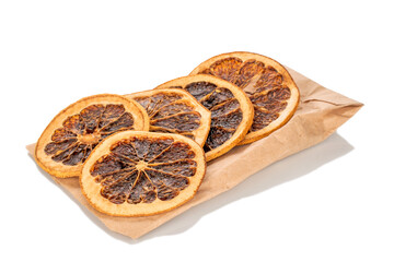 Wall Mural - Several slices of dried grapefruit, close-up, on a paper bag, isolated on a white background.