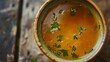 © Anna - Fresh bone broth with parsley in ceramic bowl on rustic wooden table