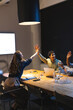 © Wavebreak Media - Diverse colleagues celebrating success with high fives during late-night office meeting