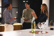 © Wavebreak Media - Diverse colleagues enjoying wine and conversation during relaxed evening office gathering