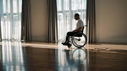 Aufkleber - Professional businessman using wheelchair navigating spacious, bright office with wooden floor, moving slowly near large windows during daytime, showcasing workplace inclusivity and independence