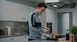 © ValueStock - A young man in a modern kitchen happily cooking a healthy meal