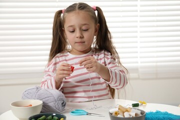 Wall Mural - Little girl making craft at white table indoors. Child creativity and handmade handicraft