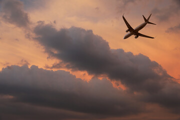 Wall Mural - Airplane flying in beautiful sky with clouds at sunset