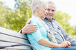 © ReadyAtTheEase/peopleimages.com - Senior couple, park and hug for support, trust or console for bad news on bench. Comfort, man or sad woman embrace outdoor for care in relationship, empathy or bonding together for love in retirement