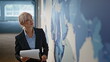 © stockbusters - Inspired marketer looking world map modern office closeup. Businesswoman working