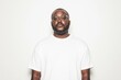 © VICHIZH - Confident man in a white t shirt and glasses against a plain background, embodying a modern and minimalist style with a focus on individuality and self expression