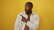 © Krakenimages.com - Young man pointing with an amazed expression over isolated yellow background, capturing an attractive and handsome adult male in a surprised moment