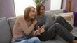 © Krakenimages.com - Women sitting together on a sofa with smiles in a cozy living room, emphasizing family, love, and sibling bond, suggesting warmth and relaxation in an indoor setting.