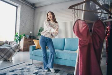 Wall Mural - Young woman dancing cheerfully in a stylish cozy living room during a relaxing day at home