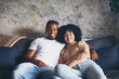 © peopleimages.com - Rest, black couple and portrait on couch at house with love, weekend romance and marriage relationship. Smile, people and partner with embrace for connection, commitment and bonding together on break