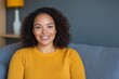 © Sanchai - people, race, ethnicity and portrait concept - happy african american young woman sitting on sofa at home