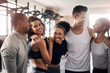 © peopleimages.com - Exercise, hug and team building with friends in gym together for solidarity, support or training. Diversity, fitness or wellness and group of people embracing in health club with personal trainer