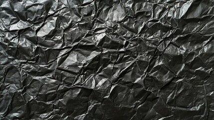 Wall Mural - The crumpled texture of black paper creating intriguing patterns and shadows