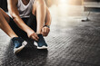 © Donson2000/peopleimages.com - Hands, gym and shoelaces for training on floor with start, routine and sneakers for fitness in morning. Person, feet and legs with shoes for workout, wellness and ready with exercise at health club