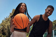 © peopleimages.com - Sports, basketball and black couple on court for exercise, workout and training for match, practice or competition. Fitness, smile and happy man and woman with ball outdoors for playing game together