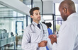 © peopleimages.com - Men, doctor and discussion with team at hospital for proposal, medical campaign or idea. Male people, surgeons or healthcare employees talking with health advice for procedure or strategy at clinic