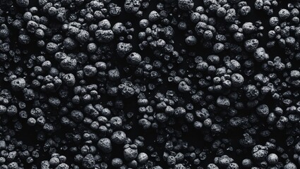 Poster - Textured black background with porous, seamless pattern of irregularly shaped dark stones for artistic and design purposes.