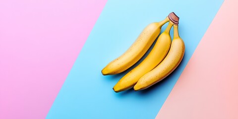 Poster - Three ripe yellow bananas arranged on a soft pastel pink and blue background creating a minimalist flat lay design with copy space for vegan themes