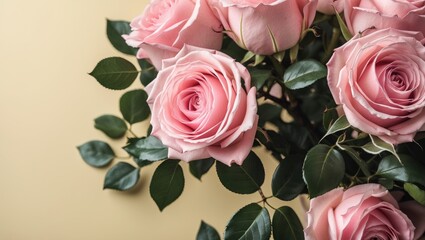 Wall Mural - Bouquet of pink roses with green leaves arranged against a soft yellow background