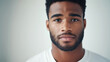 © Alexander - portrait of a confident young man with a strong presence, staring directly into the camera. The neutral white backdrop enhances his assertive expression, showcasing his self-assura
