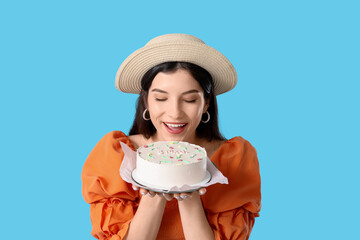 Wall Mural - Beautiful young woman with sweet bento cake on blue background. International Women's Day