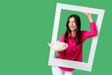 Wall Mural - Beautiful young woman with sweet bento cake and frame on green background. International Women's Day