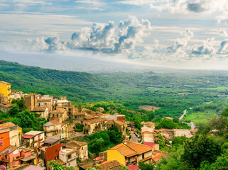 Wall Mural - panoramic landscape with view from above of beautiful antique italian town with orange roofs, green gardens and beautiful background