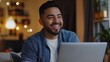 © OLEKSANDR - Happy Hispanic deaf man talking in deaf language on a video call on his laptop.