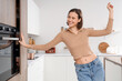 © Pixel-Shot - Young woman dancing near drawer in kitchen