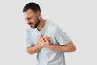 © Pixel-Shot - Young man suffering from chest pain on white background