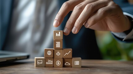 Poster - A person is building a tower of wooden blocks with various icons on them