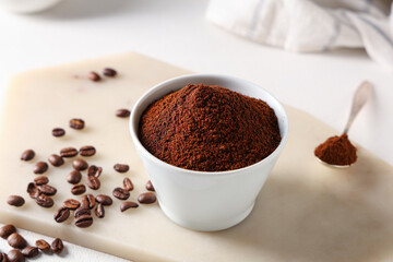 Wall Mural - Bowl of coffee powder with beans and spoon on white background