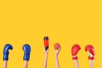 Wall Mural - Female hands with sports equipment on yellow background