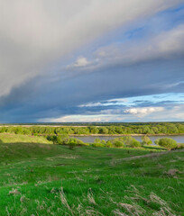 Wall Mural - cloudy sky with a green field in the background