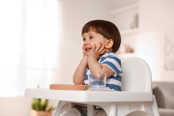 Canvas Print - Cute little boy sitting in high chair at home