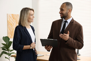 Wall Mural - Coworkers with clipboard working together in office