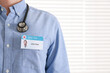 © New Africa - Doctor with badge in hospital, closeup. Space for text