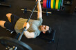 © AntonioDiaz - Male athlete performing bench press, gripping barbell intensely, building muscle strength during rigorous gym training session