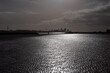 © Philip - Lone person in silhouette walking dogs on beach with city of Liverpool skyline in distance