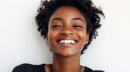 Wall Mural - Portrait of a joyful young woman smiling brightly against a neutral background with natural lighting