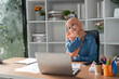 © wichayada - Muslim woman experiencing neck discomfort while working at her desk.