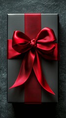 Wall Mural - Elegant Black Gift Box Adorned With a Red Satin Ribbon, Perfect for Celebrations or Special Occasions