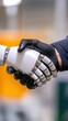 © Denis Tuev - A robotic hand shakes hands with a human, a symbol of cooperation between technology and people.